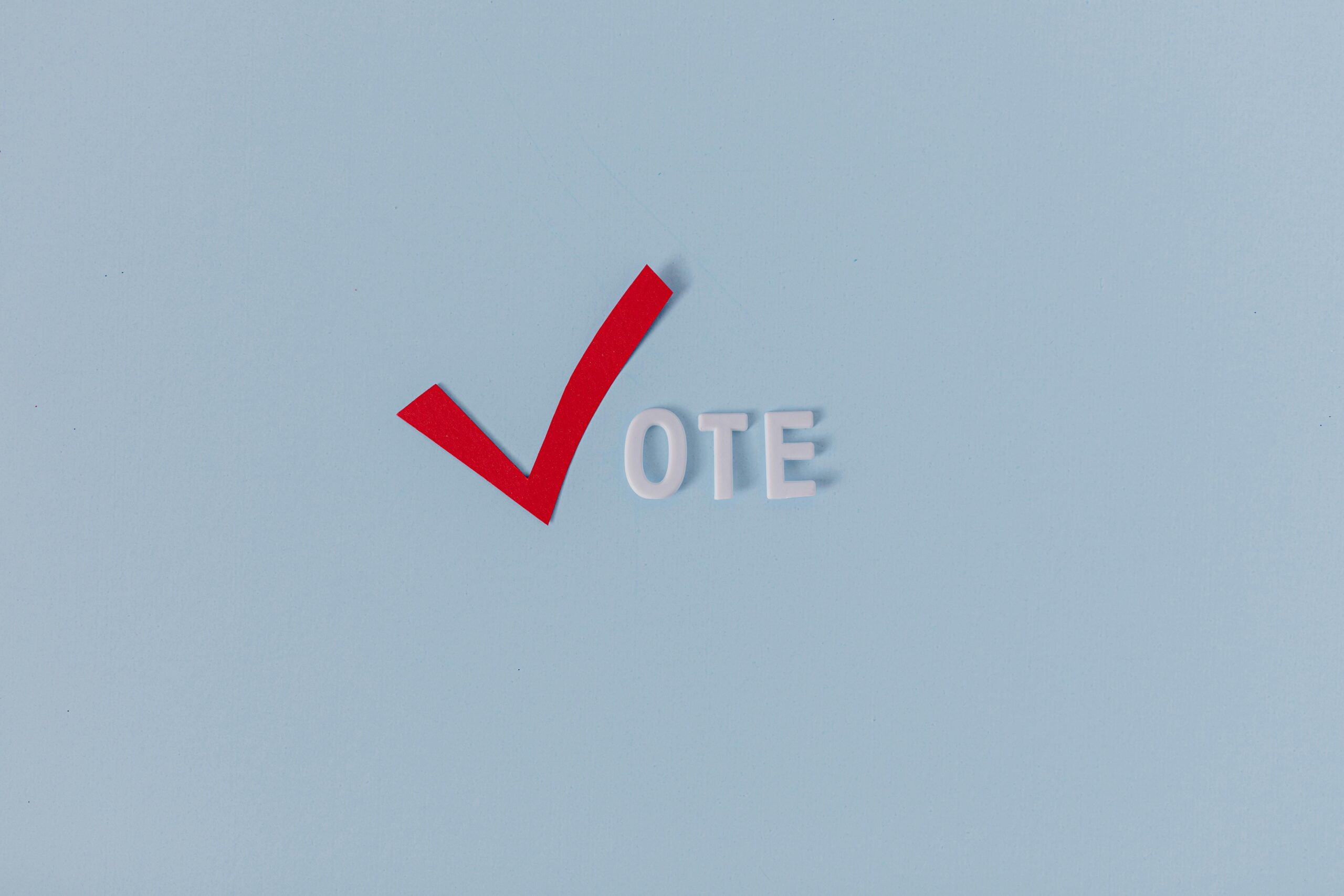 Red check mark with the word "VOTE" on a blue background, symbolizing election participation.